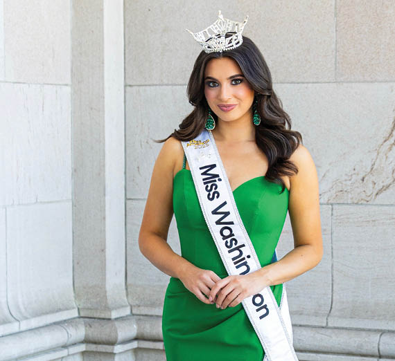 Un homme à la barbe et aux bras tatoués se tient les bras croisés